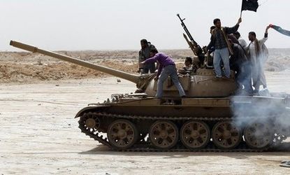 LIbyan rebels ride a tank in the eastern part of the country.