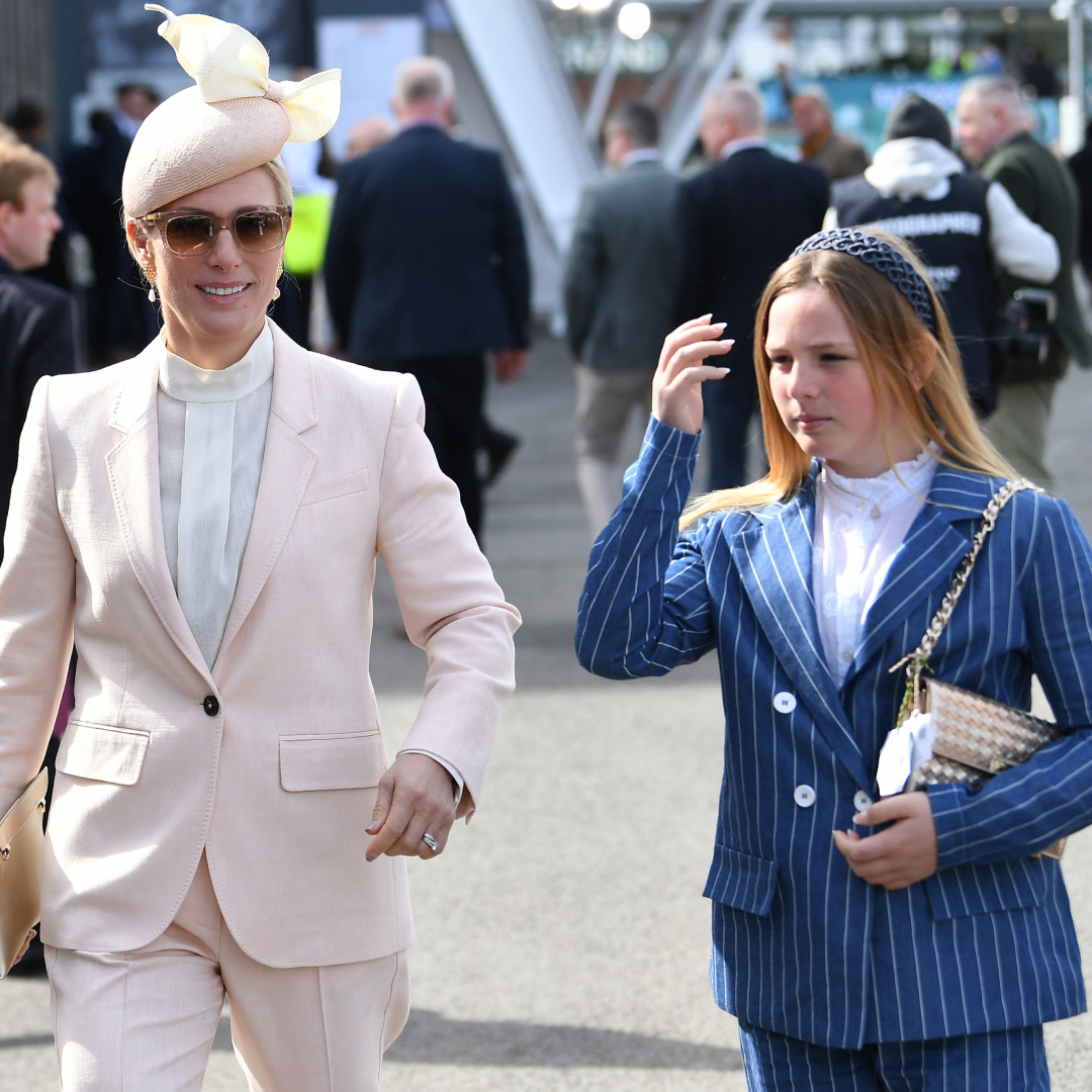 Zara Tindall wearing a pink suit walking next to Mia Tindall in a blue striped suit