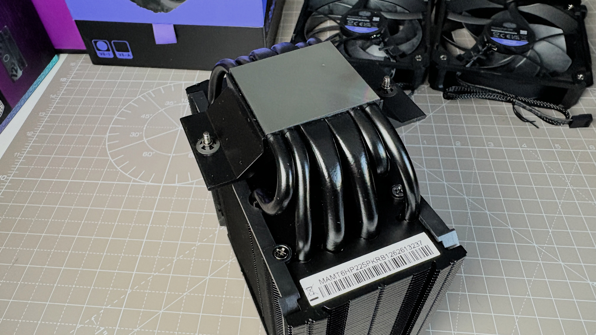 The Cooler Master V8 Ace 3DHP installed on a test bench and on its box.