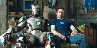 Robert Downey Jr. Tony Stark sits next to Iron Man suit Marvel