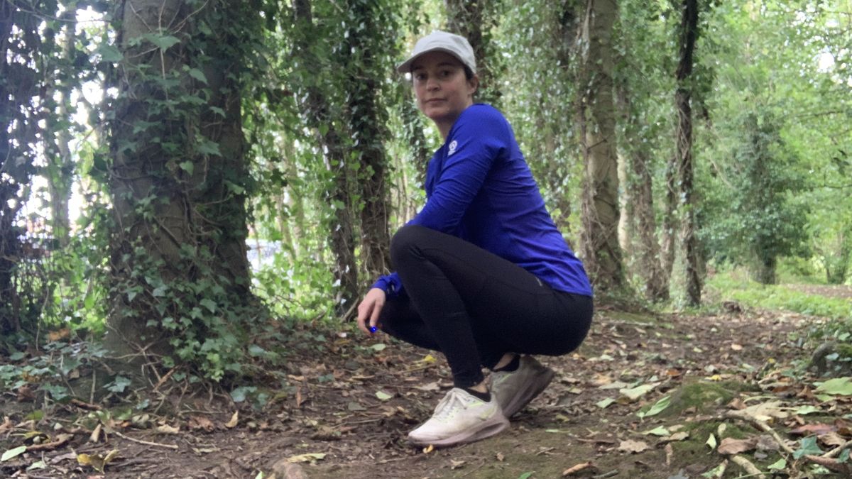 Trail runner in leggings crouching down