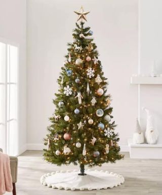 Ornaments on a Christmas tree against a white wall.