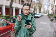 Woman vaping and looking at her phone