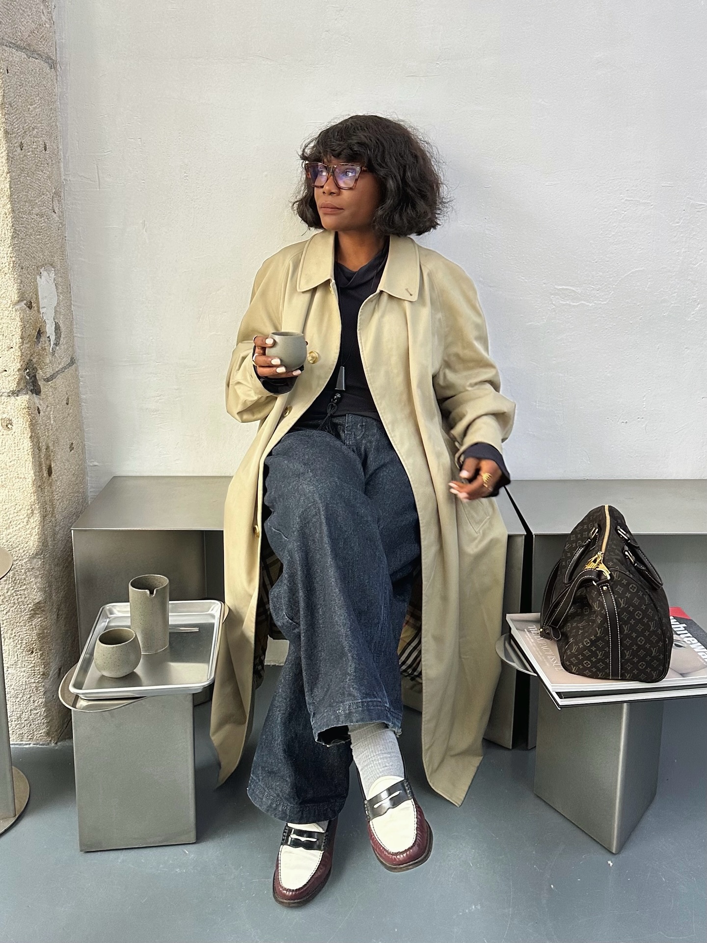 Influencer Frann Fyne wearing anti-trend outfit of trench coat with jeans and loafers