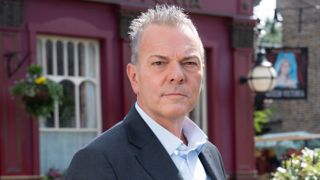 Michael French as David Wicks in EastEnders wearing a suit and standing in front of the pub