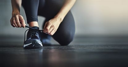 Woman lacing up her trainers