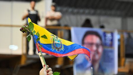 Mourner holds Ecuadorian flag at Villavicencio's funeral