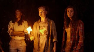 Nia Sondaya as Teen Akilah, Liv Hewson as Teen Van and Sophie Nélisse as Teen Shauna in Yellowjackets, episode 3, season 3 in a dark cave looking scared