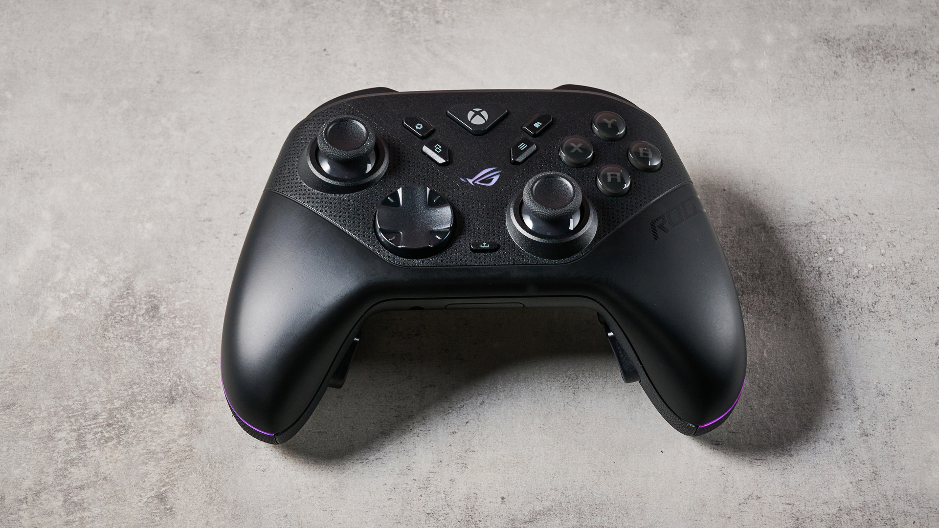 The Asus ROG Raikiri II Xbox Wireless sat on a stone-effect surface.