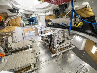 the inside of a cramped cone-shaped spacecraft featuring four seats