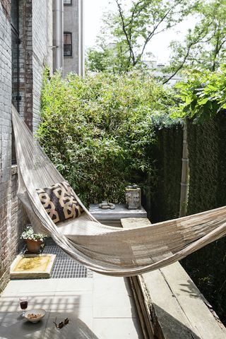 small urban garden with hammock and green walls