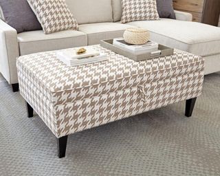 A beige and white coffee table ottoman with dogtooth detail