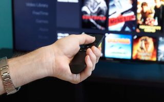A hand using the Fire stick remote control