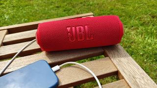 JBL Flip 7 in red with a phone attached via USB-C