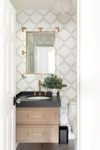 powder room with geometric wallpaper and brass fittings