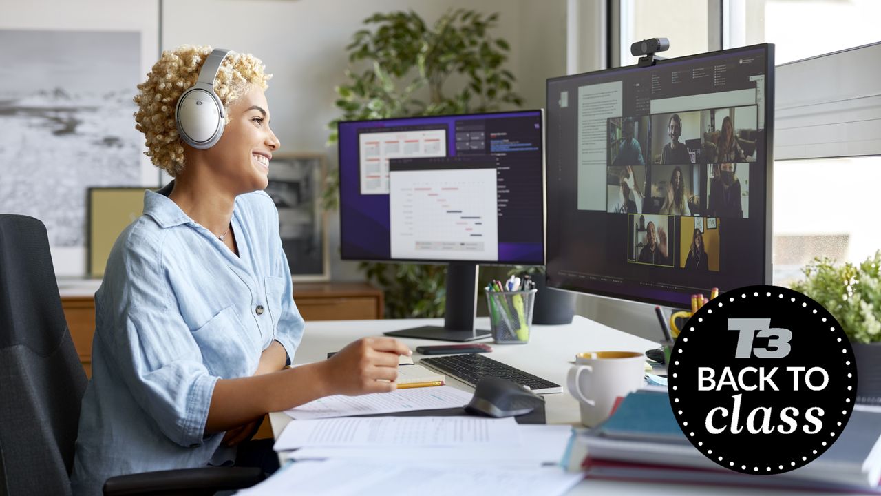 Student at her desk with headphones, a monitor, a webcam, a keyboard and her notes