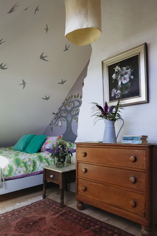 Bedroom with blue bed and wooden storage