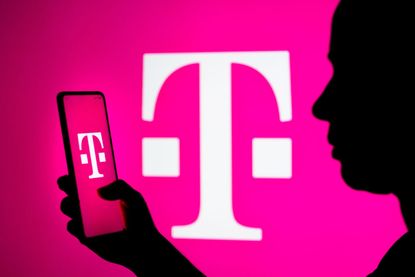 T-Mobile logo in background and on phone held by sillouette