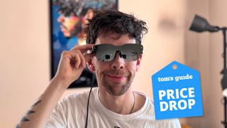 Person wearing RayNeo Air 3s XR Glasses with fingers on temple looking forward with Tom's Guide Price Drop badge