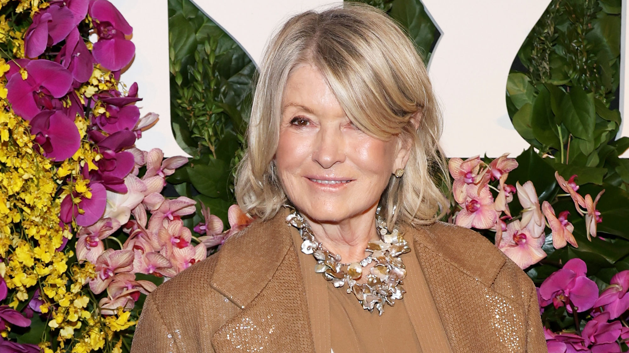 Martha Stewart stands in front of floral background at The New York Botanical Garden hosts The Orchid Dinner at The Plaza Hotel 