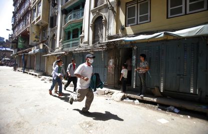 A man runs to safety in Nepal.