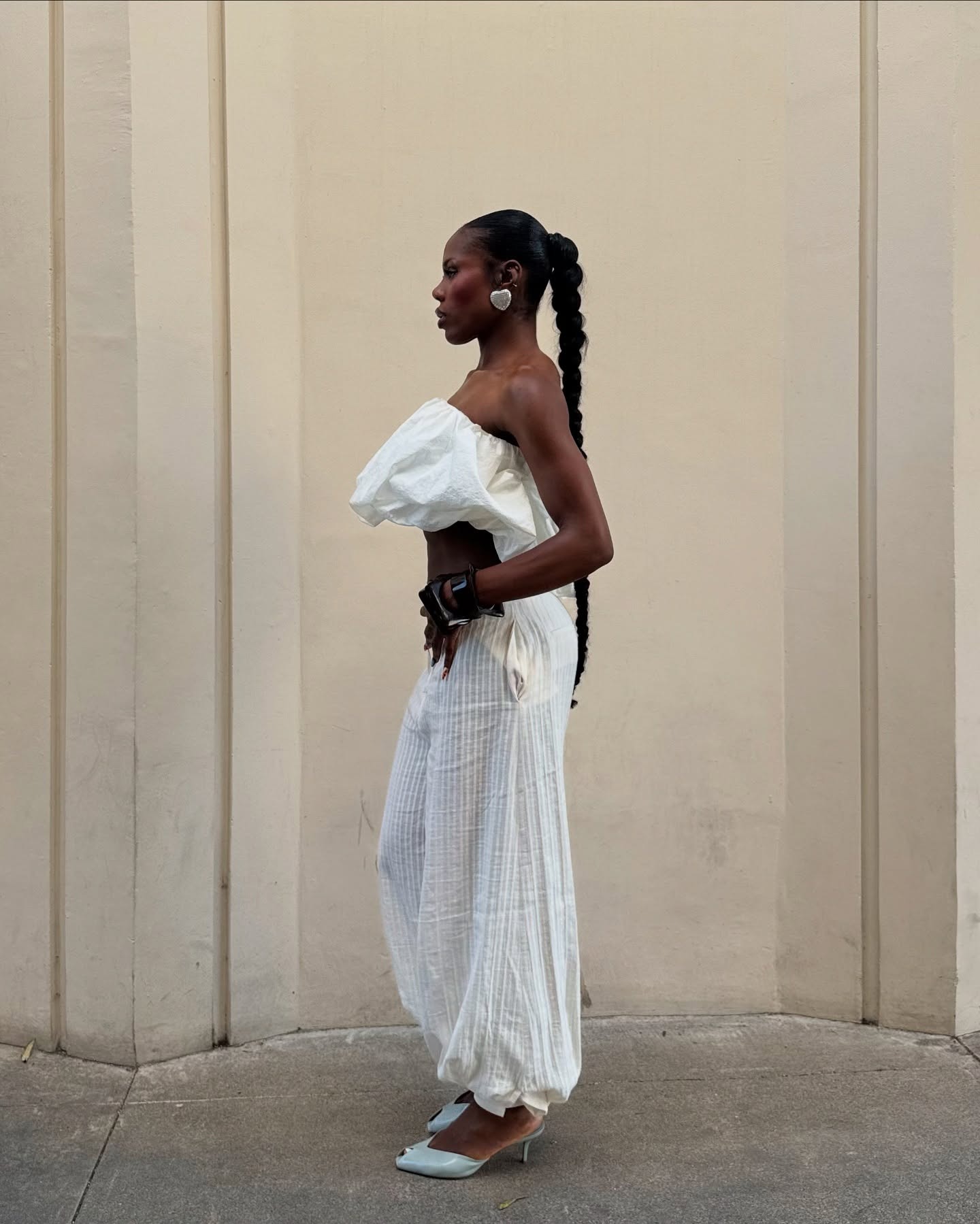 @indyabrown wearing a white strapless top with white genie pants and heels.