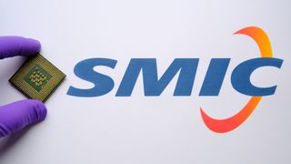 Gloved hand holding a chip next to the logo of SMIC