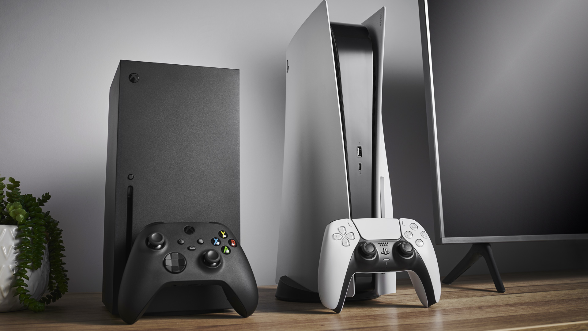 Xbox Series X and PS5 next to each other on a desk.