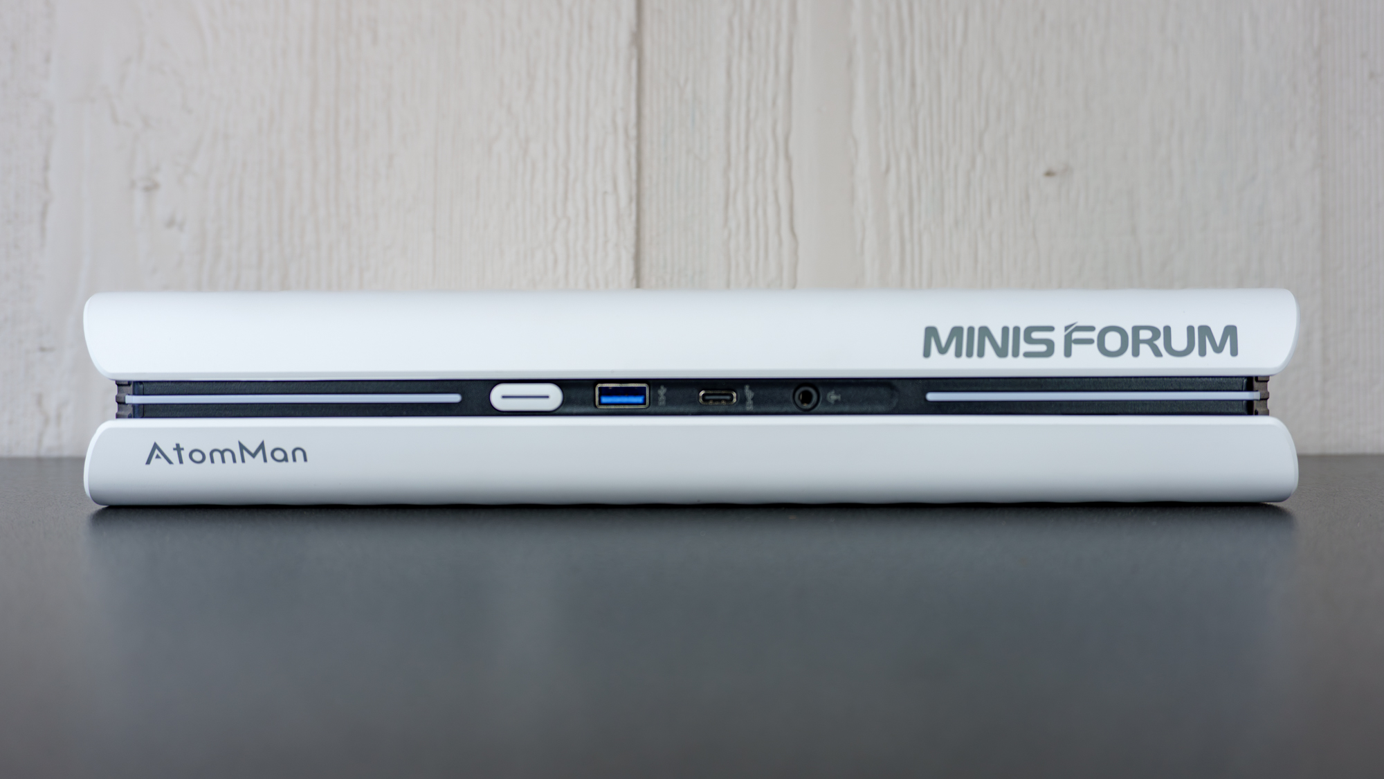 The Minisforum G1 Pro lying flat on a table showing off its front ports