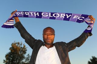 William Gallas holds a Perth Glory scarf after signing for the A-League club in November 2013.