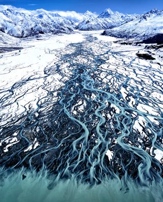 Aerial view from a helicopter of the glacial blue waters of the Tasman River