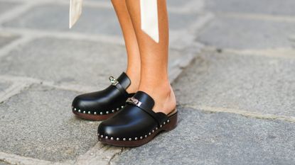 Xenia Adonts wears black leather Hermes studded clogs / shoes, during the Twilly By Hermes : Launch Party In Paris, on July 01, 2021 in Paris, France