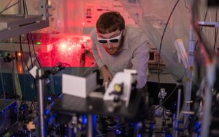 Tom Langin, a doctoral candidate at Rice University, makes an adjustment to an experiment that uses 10 lasers of varying wavelengths to laser-cool ions in a neutral plasma.