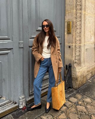 Influencer wearing a camel coat and jeans