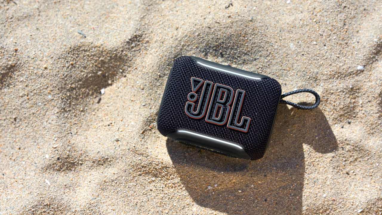 The JBL Go 5 on a beach.