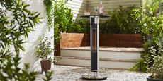 the Swan Al Fresco Column Patio Heater, the best patio heater, placed in a garden on a brick patio