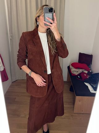 Eliza Huber in the dressing room at Madewell's new SoHo flagship in New York wearing a brown suede blazer and matching midi skirt.