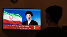 Man watches Iran TV's statement from new leader Ayatollah Mojtaba Khamenei