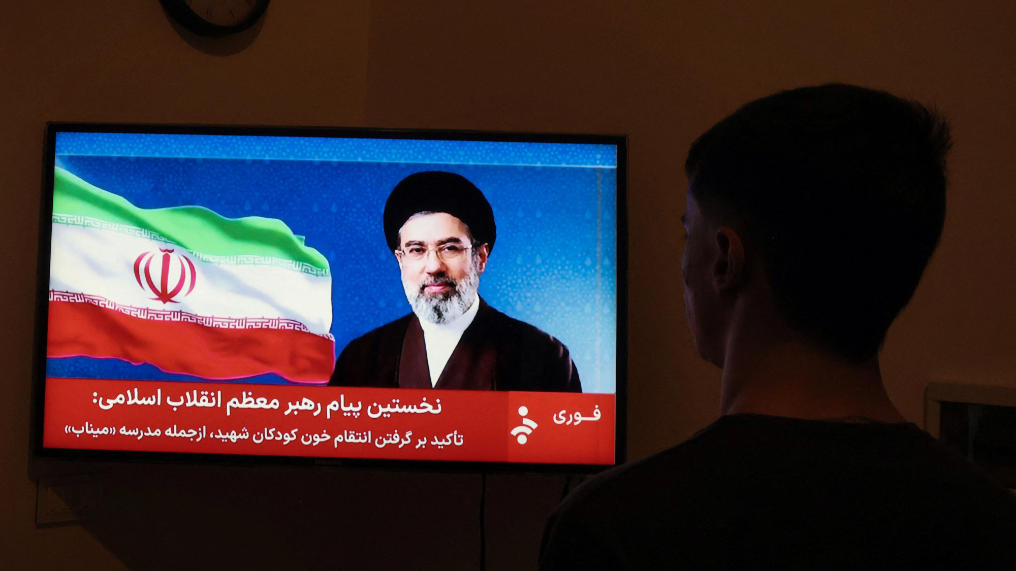 Man watches Iran TV's statement from new leader Ayatollah Mojtaba Khamenei