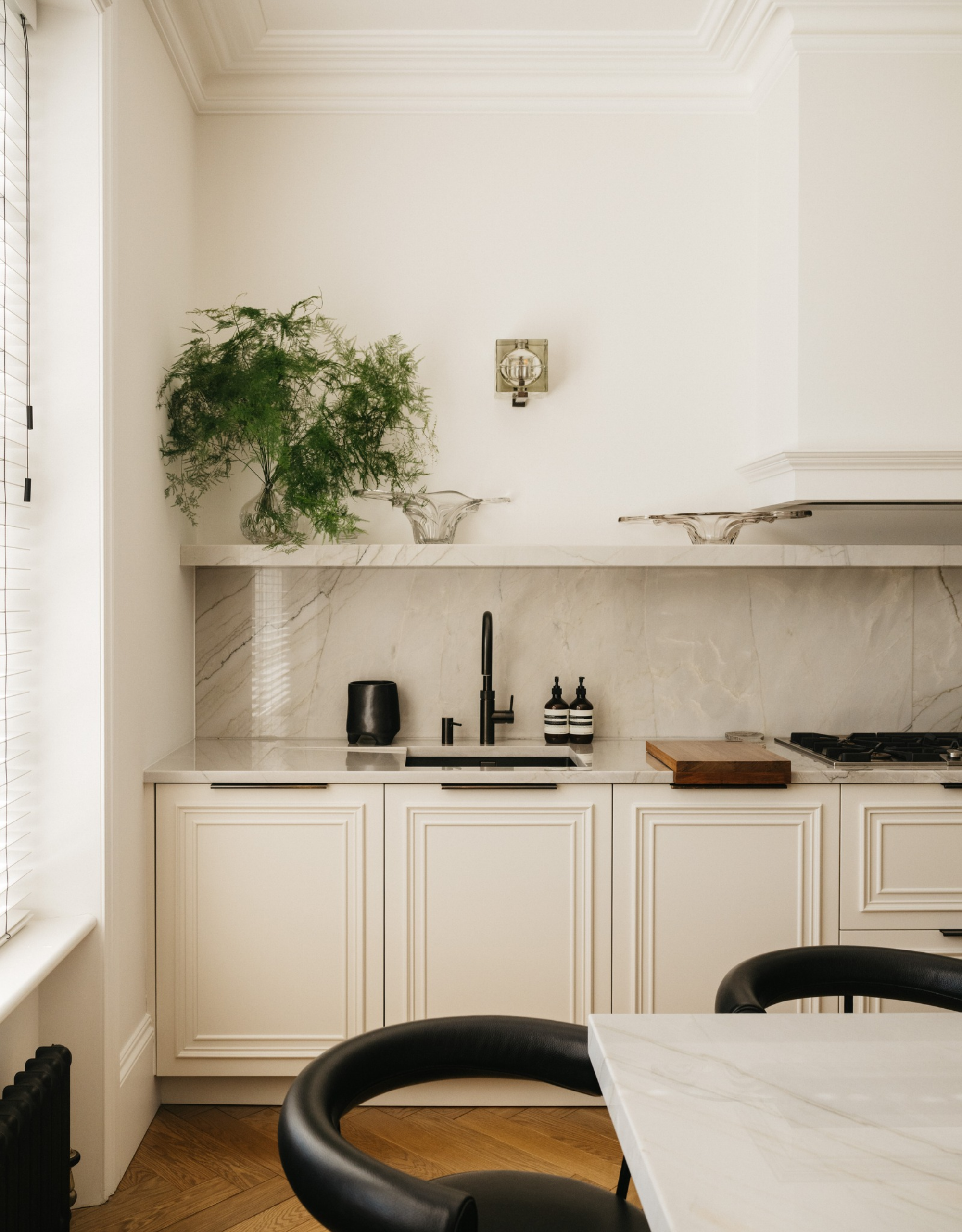 neutral and light kitchen with white cabinetry and marble counters