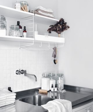 white metal string system over a stainless steel worktop and sink in a laundry/utility room