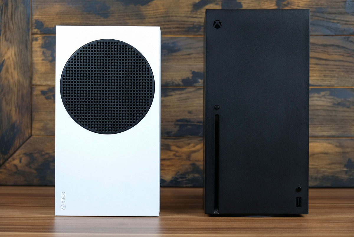 An Xbox Series S console and an Xbox Series X console side by side against a wood panel background