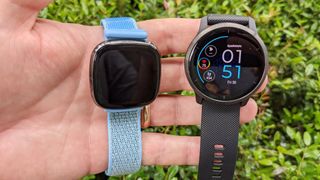 The Fitbit Sense (left) and Garmin Venu 2 (right) held in one hand