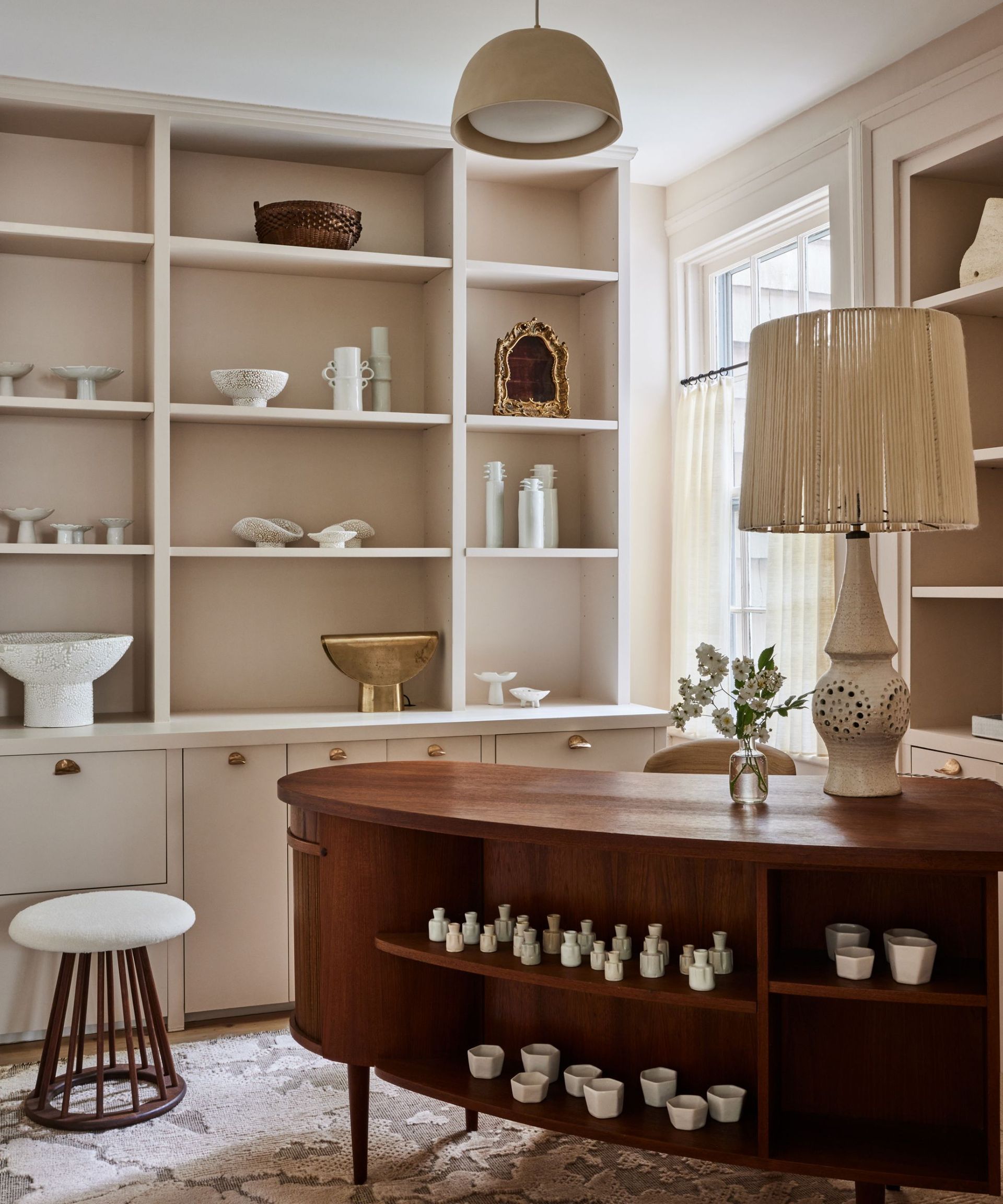 Wooden table, peach shelves and walls, white stool