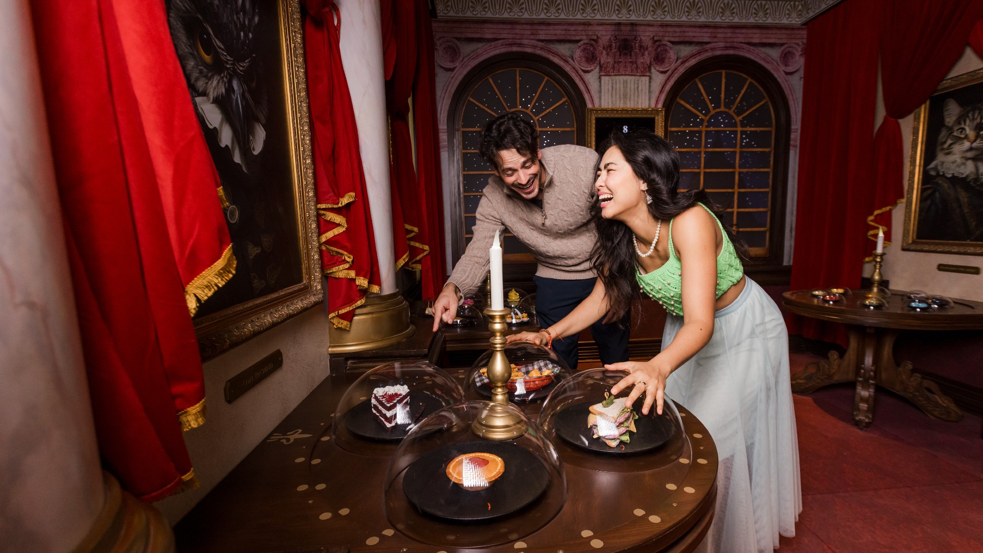 A man and a woman laugh in a challenge room at Hijinx Hotel