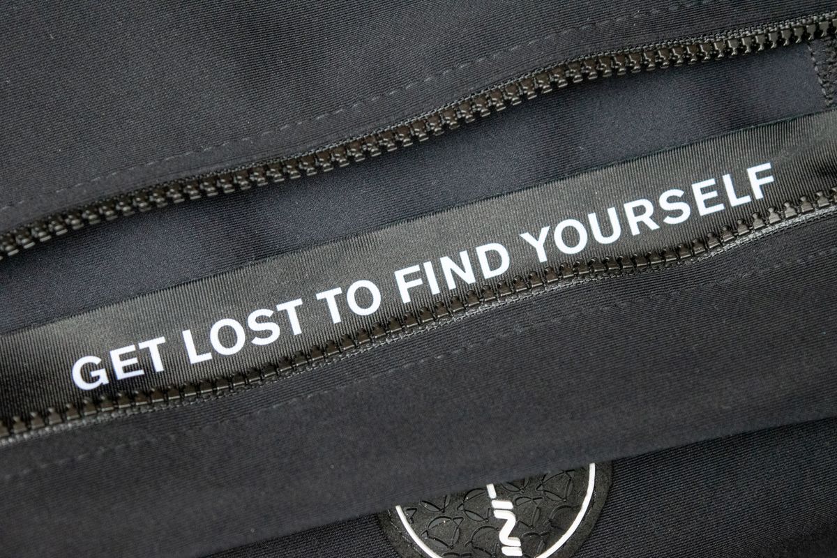 The gilet zipper guard with 'get lost to find yourself' printed on