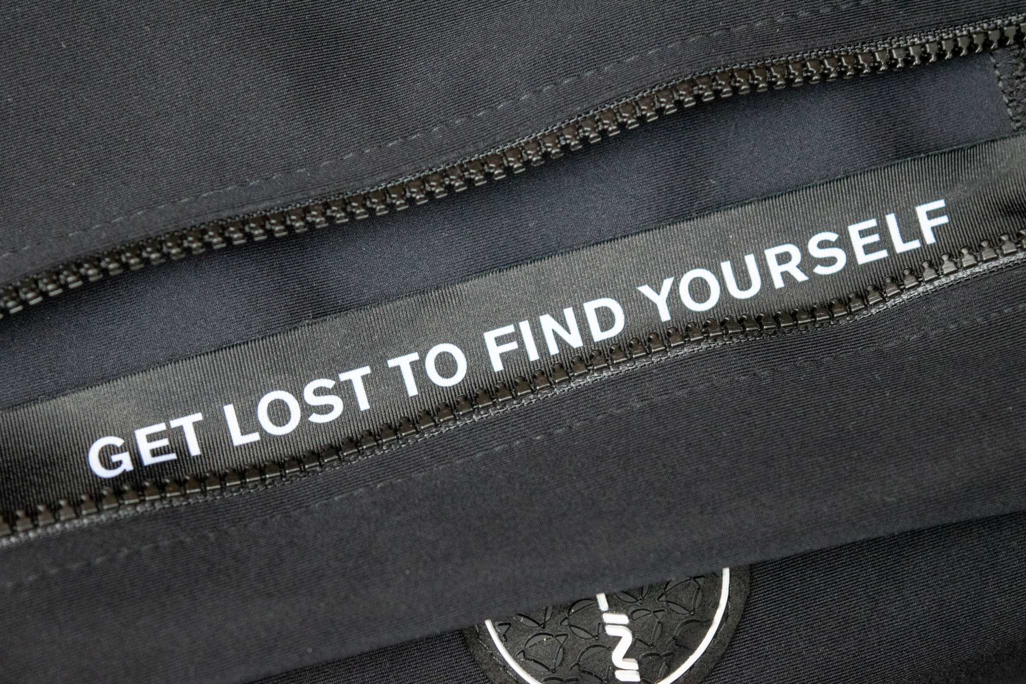 The gilet zipper guard with 'get lost to find yourself' printed on 