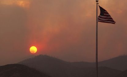 The sun sets Wednesday as smoke from the Las Conchas wildfire envelopes the hills near the Los Alamos National Laboratory in New Mexico.