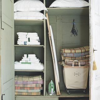 wooden cabinet with towels and cushion