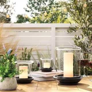 Three black and clear candle holders on an outdoor dining table from Studio McGee's collection with Target